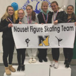 Nauset's new figure skating club posing with a banner