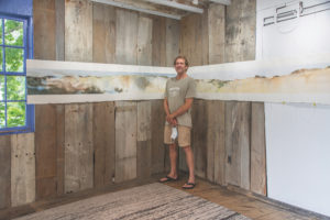 Mark Brennan with his epic watercolor, Edge of the Continent/Center of the World, at Off Main Gallery in Wellfleet. (Photo Nancy Bloom)